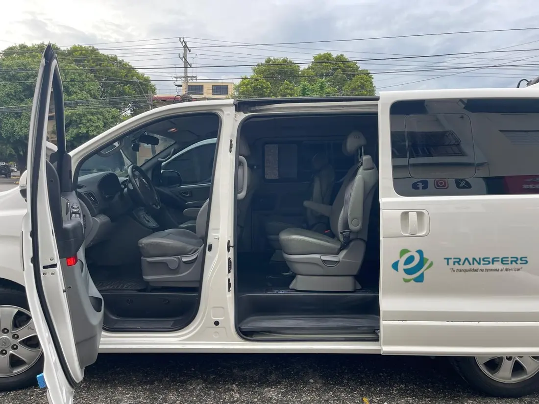 Van blanca de eTransferSDQ con las puertas abiertas y los asientos de cuero a la vista
