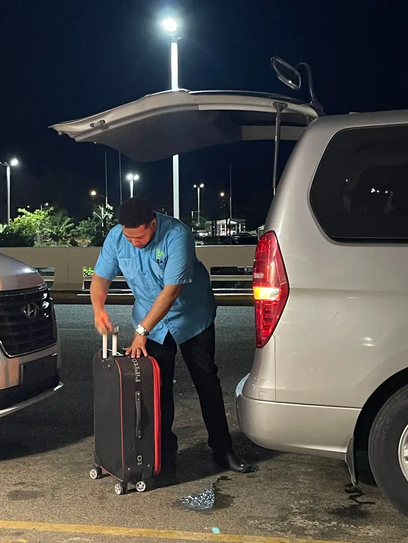 Capitán de eTransferSDQ sube la maleta de un pasajero a la van
