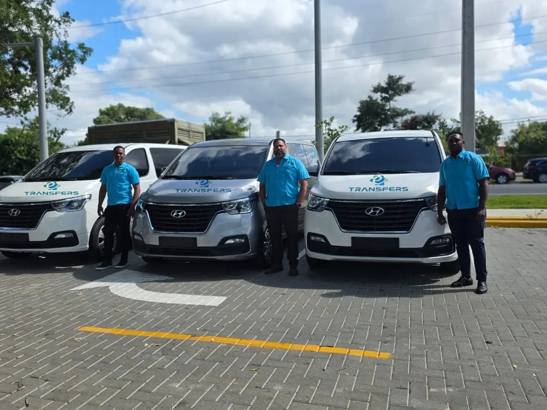 Tres Capitanes de eTransferSDQ con camisa azul junto a sus vans
