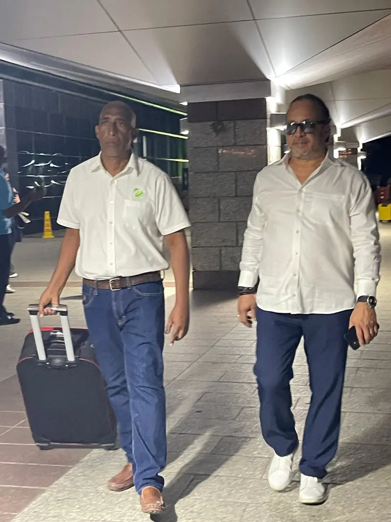 Personal de eTransferSDQ acompaña a un pasajero con su maleta a la salida del aeropuerto