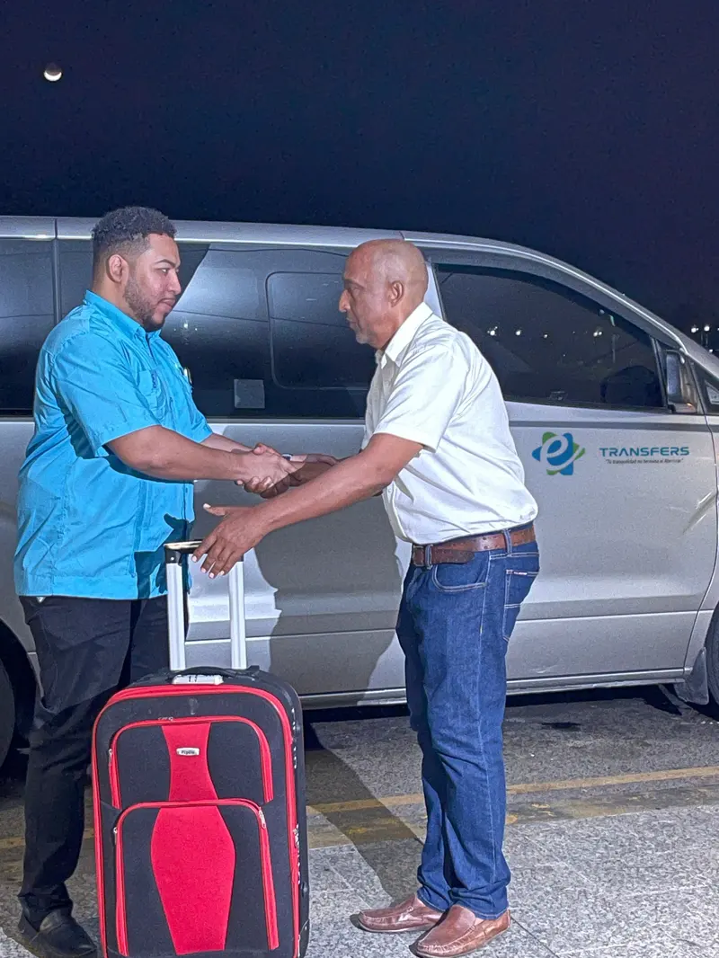 El conductor de eTransferSDQ entrega un cliente al edecán junto a la van