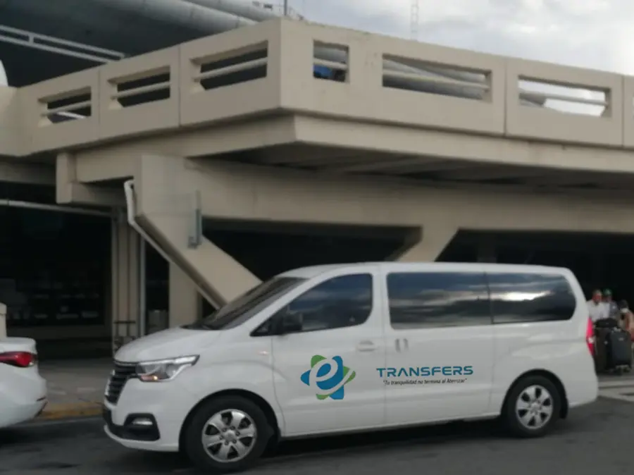 Van blanca frente a la terminal de llegadas